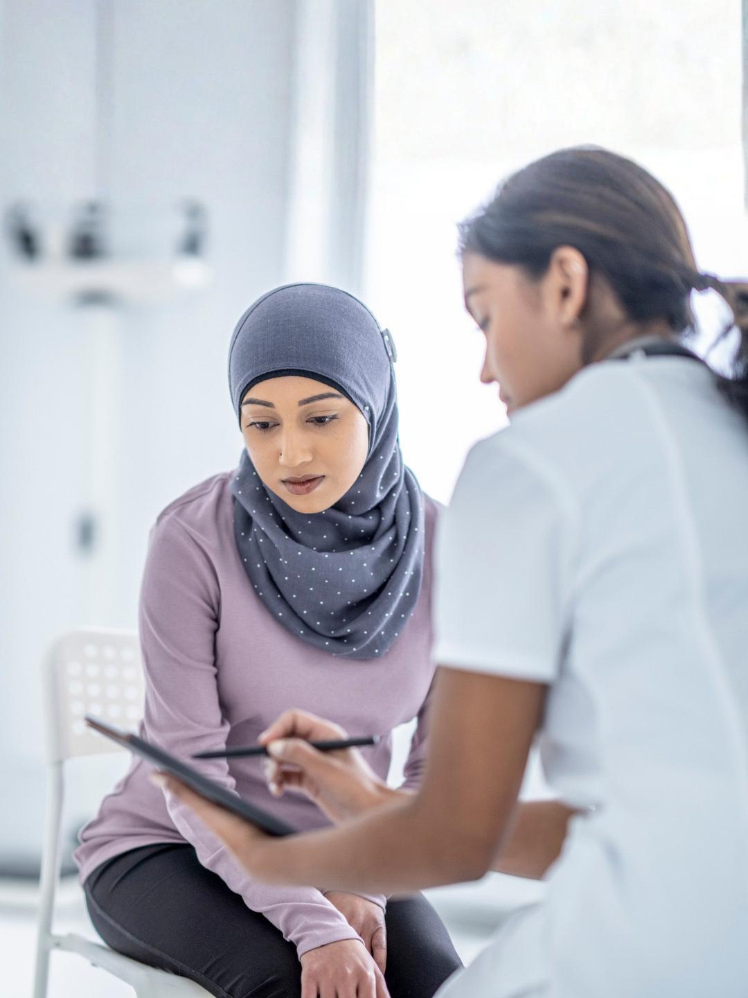 A muslim woman speaking with a healthcare provider