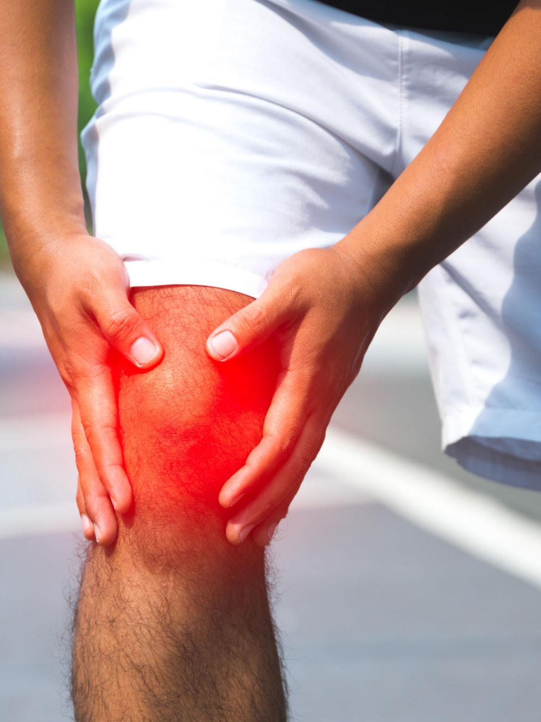 A man holding his knee experiencing joint pain