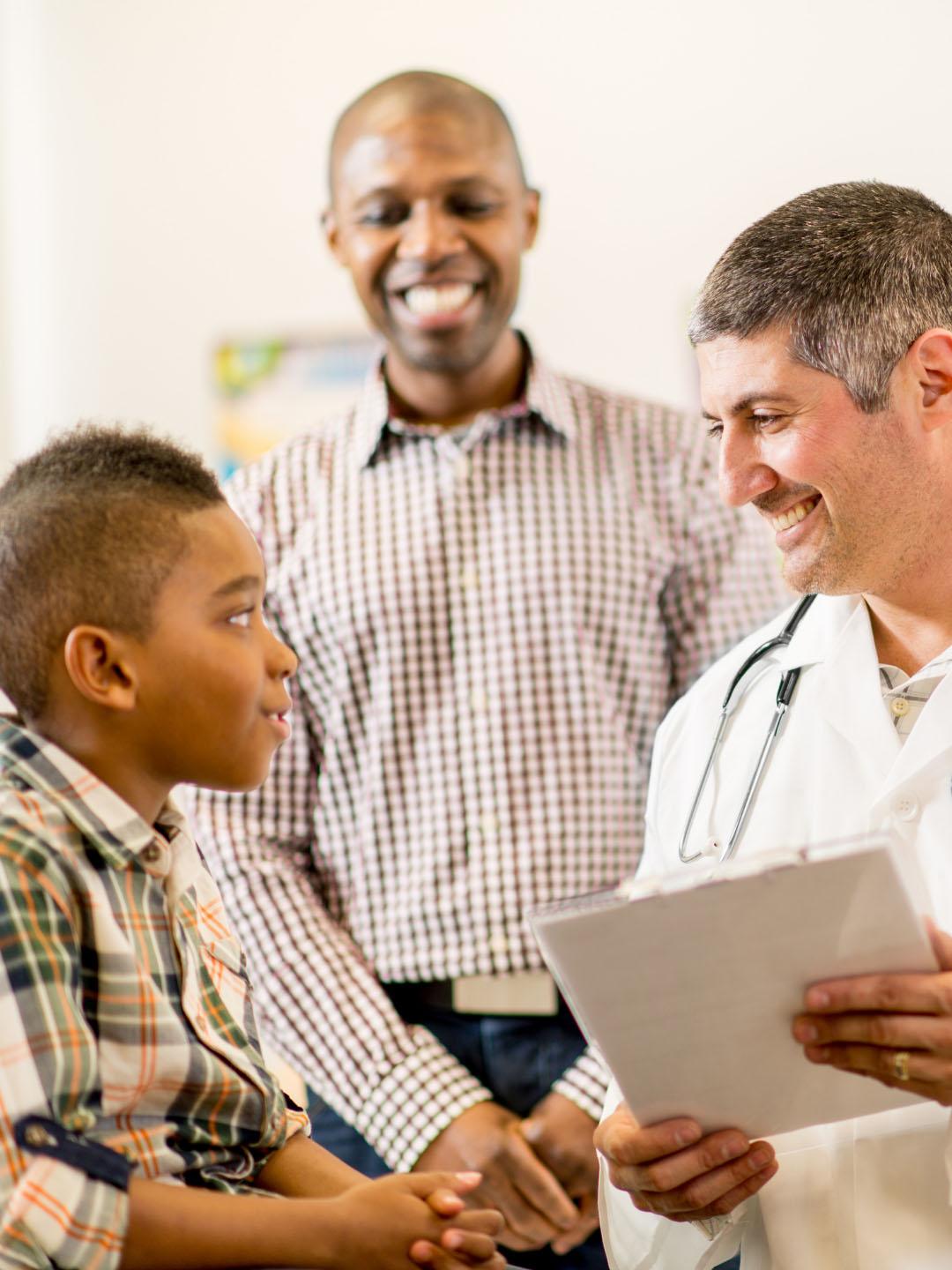 Doctor speaking with a boy with his father present