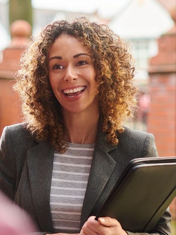 Social Worker smiling at the front door of a house
