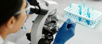 Research looking into a microscope