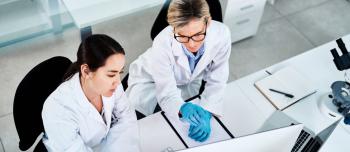 Two researchers in a lab looking at a computer screen