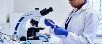 A woman in a lab conducting research by examining blood