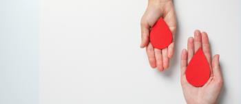 Two hands holding blood drop cut outs