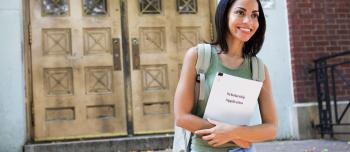 Woman walking with scholarship application book
