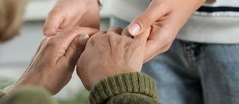 A caregiver holding someones hands