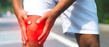 A man holding his knee experiencing joint pain