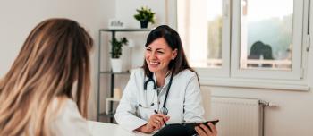 A doctor sitting across from her patient and discussing care