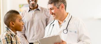 Doctor speaking with a boy with his father present