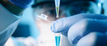 Person placing droplet in lab equipment.