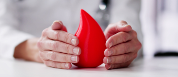 A pair of hands by a red blood drop