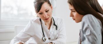 Two women, one doctor and a patient, looking over a medical document