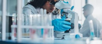 Scientist using Microscope in a clinical trial