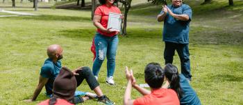 Group of people at a park participating in an award ceremony