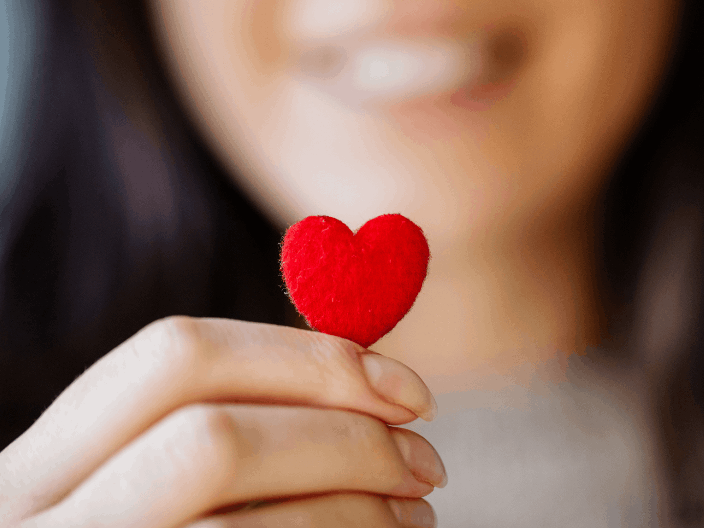 A woman holding a small red heart